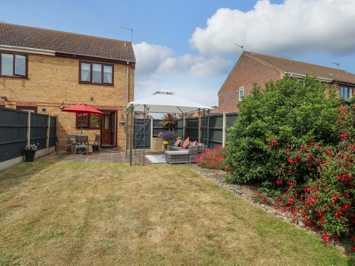 A garden with a table and chairs under a canopy at Breydon Cottage in Bradwell near Gorleston-On-Sea