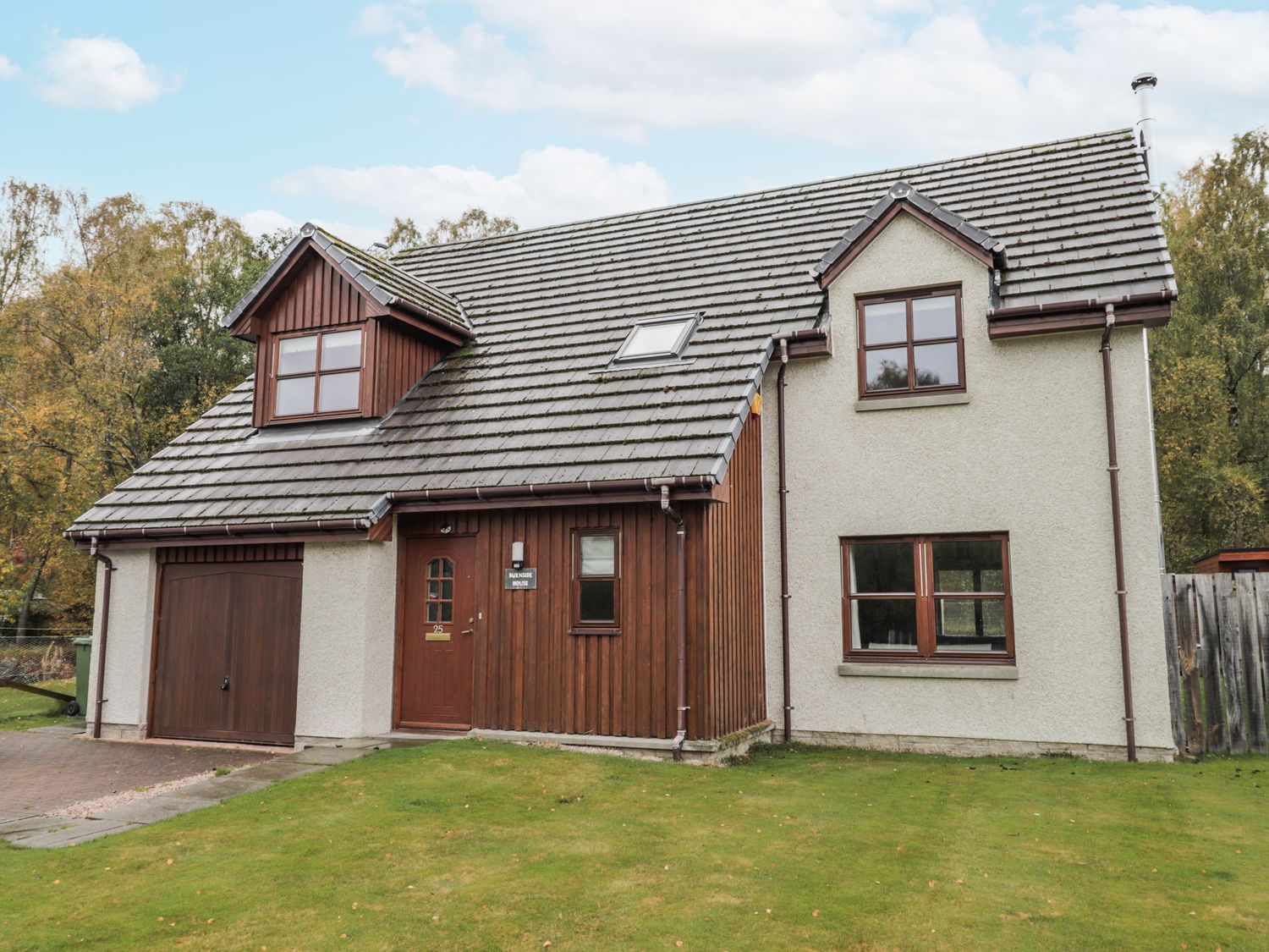 A house with a garage and windows at Burnside House in Aviemore