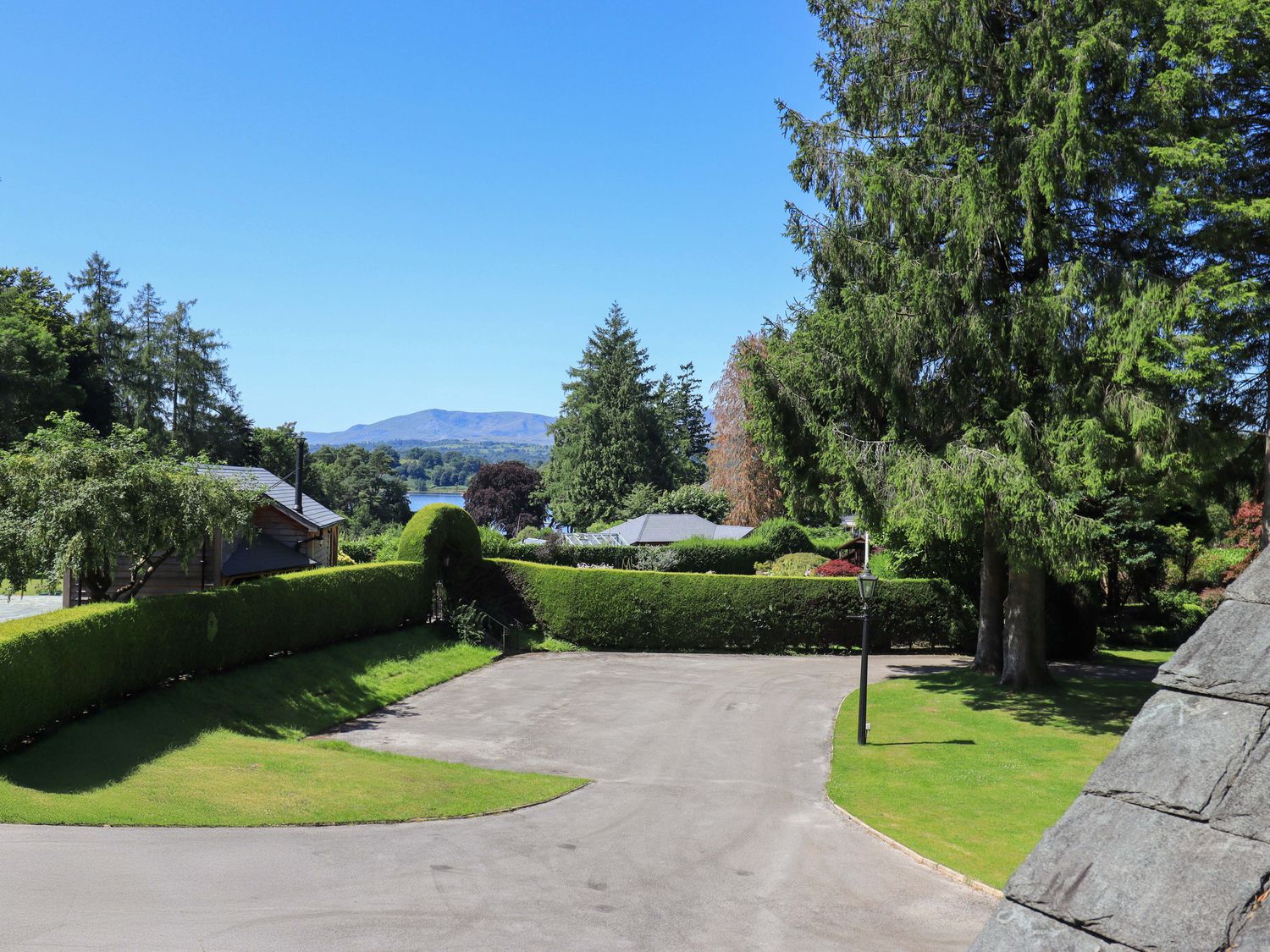 A scenic outdoor view with trees and houses near a lake at Lakeside Cottage, Ecclerigg near Ambleside