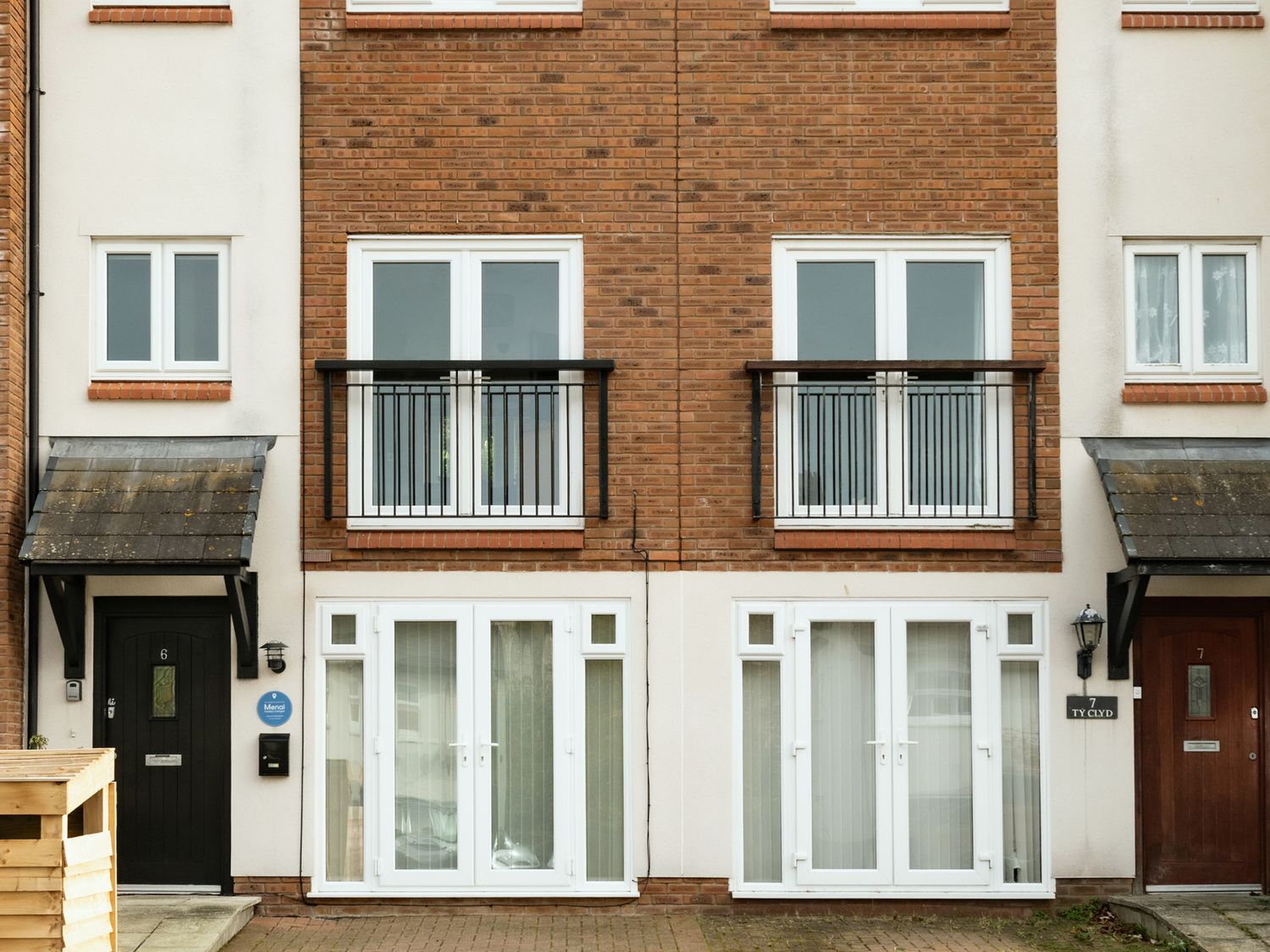 A building facade with balconies and doors at Coed y Felin in Conwy