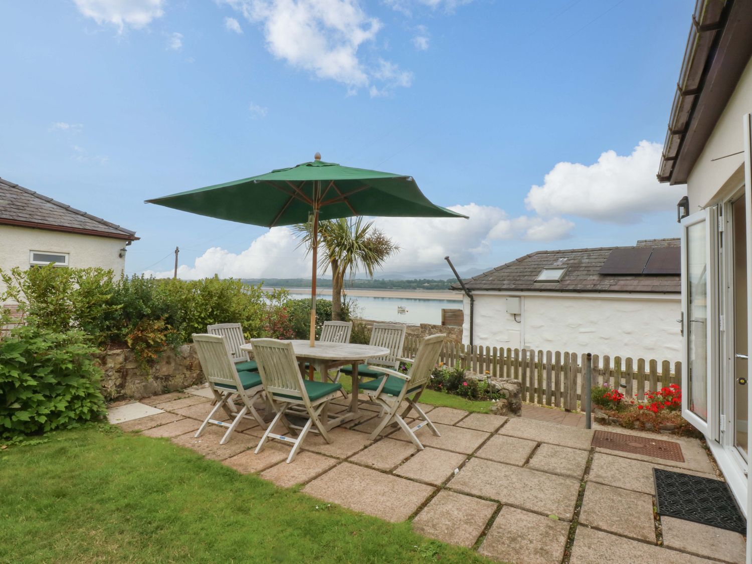 A garden with a table and chairs at Menai Cottage in Brynsiencyn