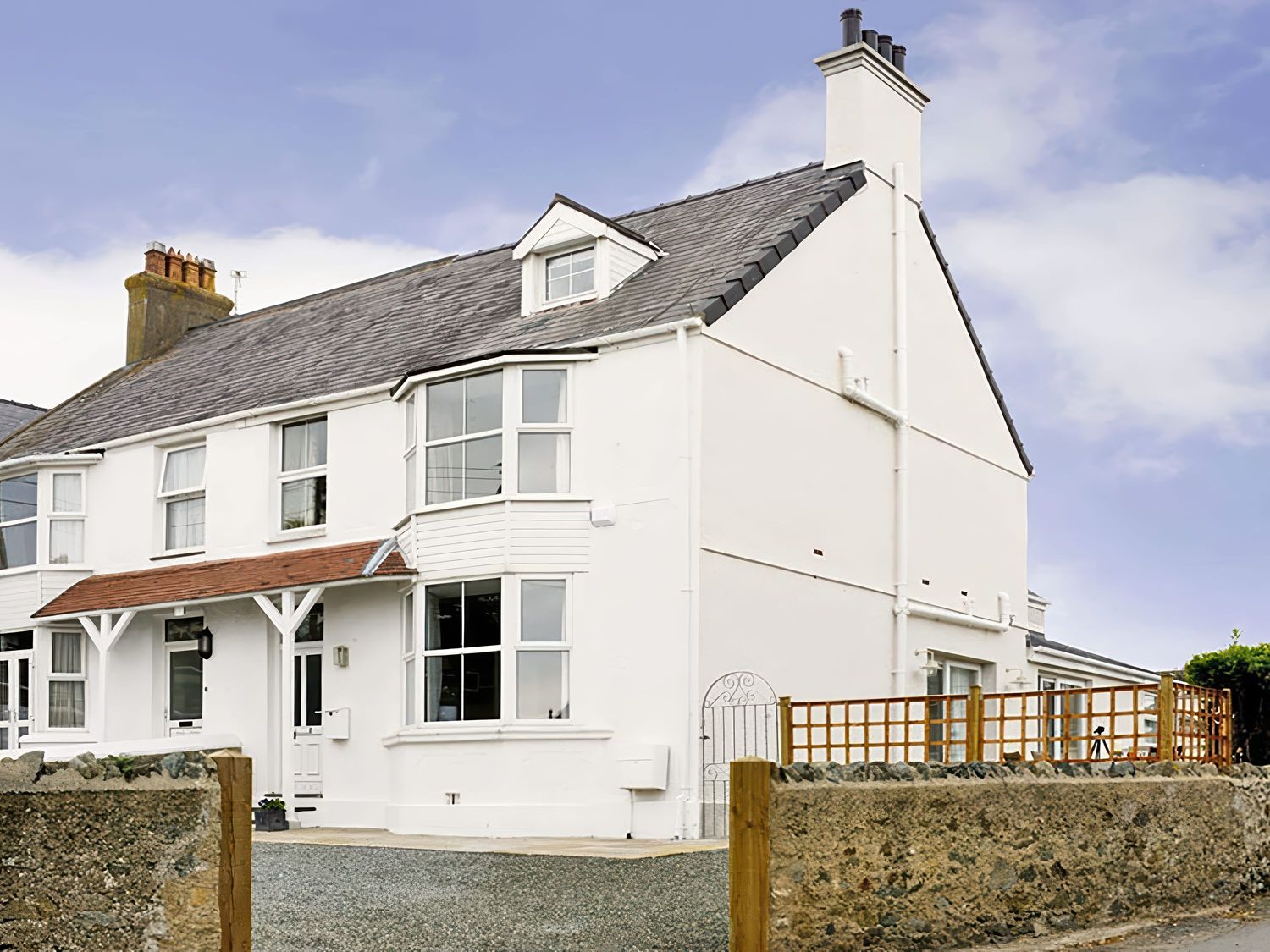 A house with a garden and fence at West View in Rhosneigr