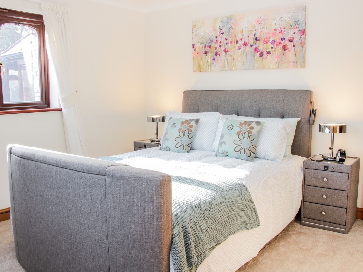 A bedroom with a grey upholstered bed and matching bedside tables with lamps at Court Farm in Neen Sollars near Cleobury Mortimer