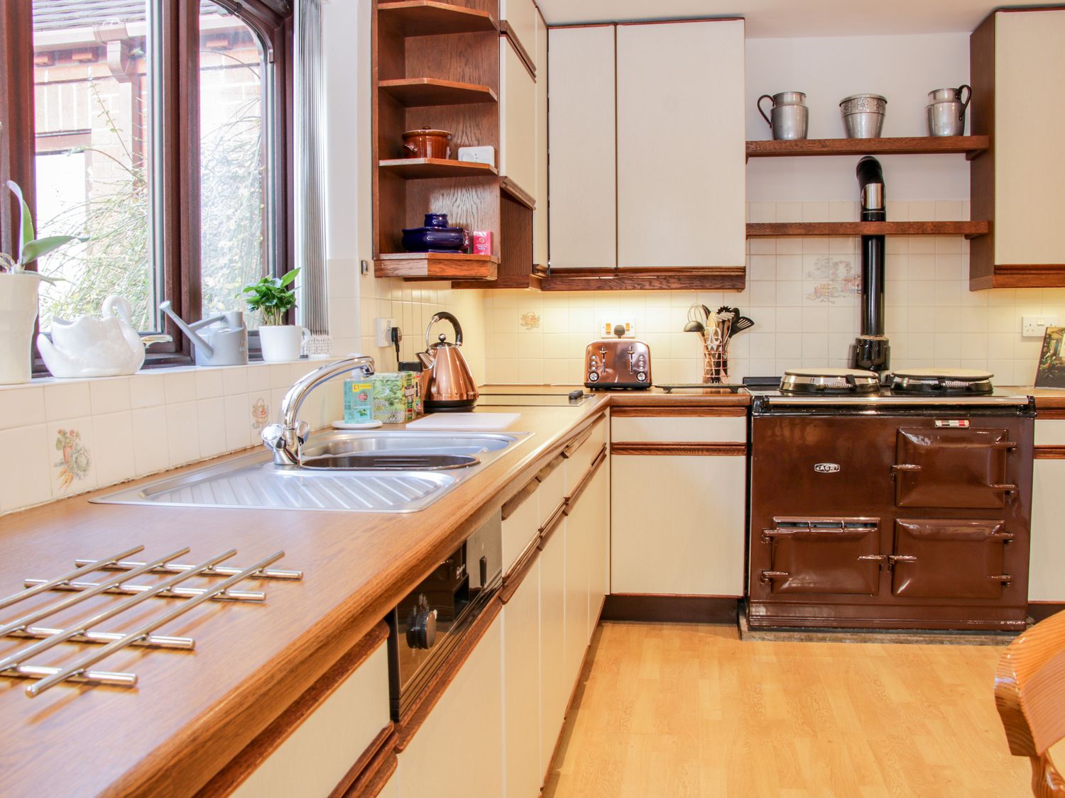 A kitchen with a sink countertop oven toaster kettle and stove at Court Farm in Neen Sollars near Cleobury Mortimer