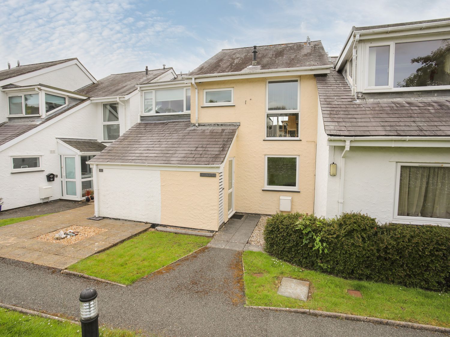 Exterior view of connected houses with tiled roofs grass and pathways at Delfryd in Y Felinheli