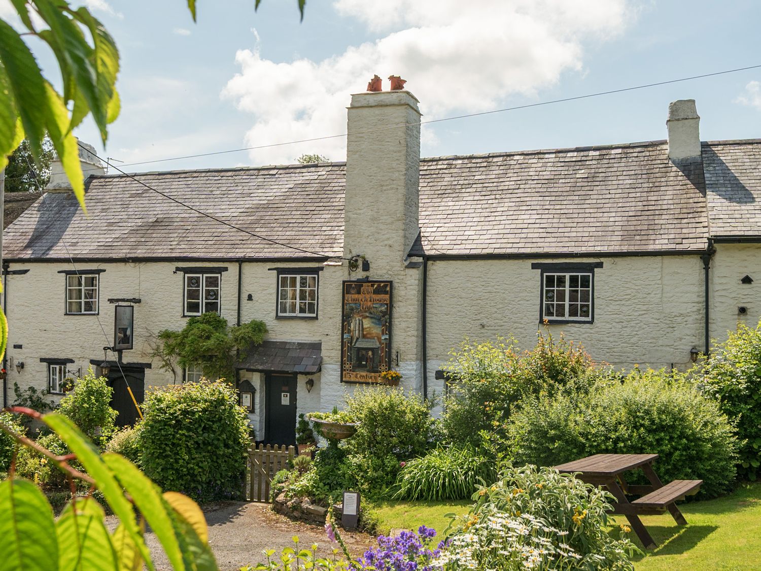 A house with a garden and seating area at The Old Church House in Torbryan