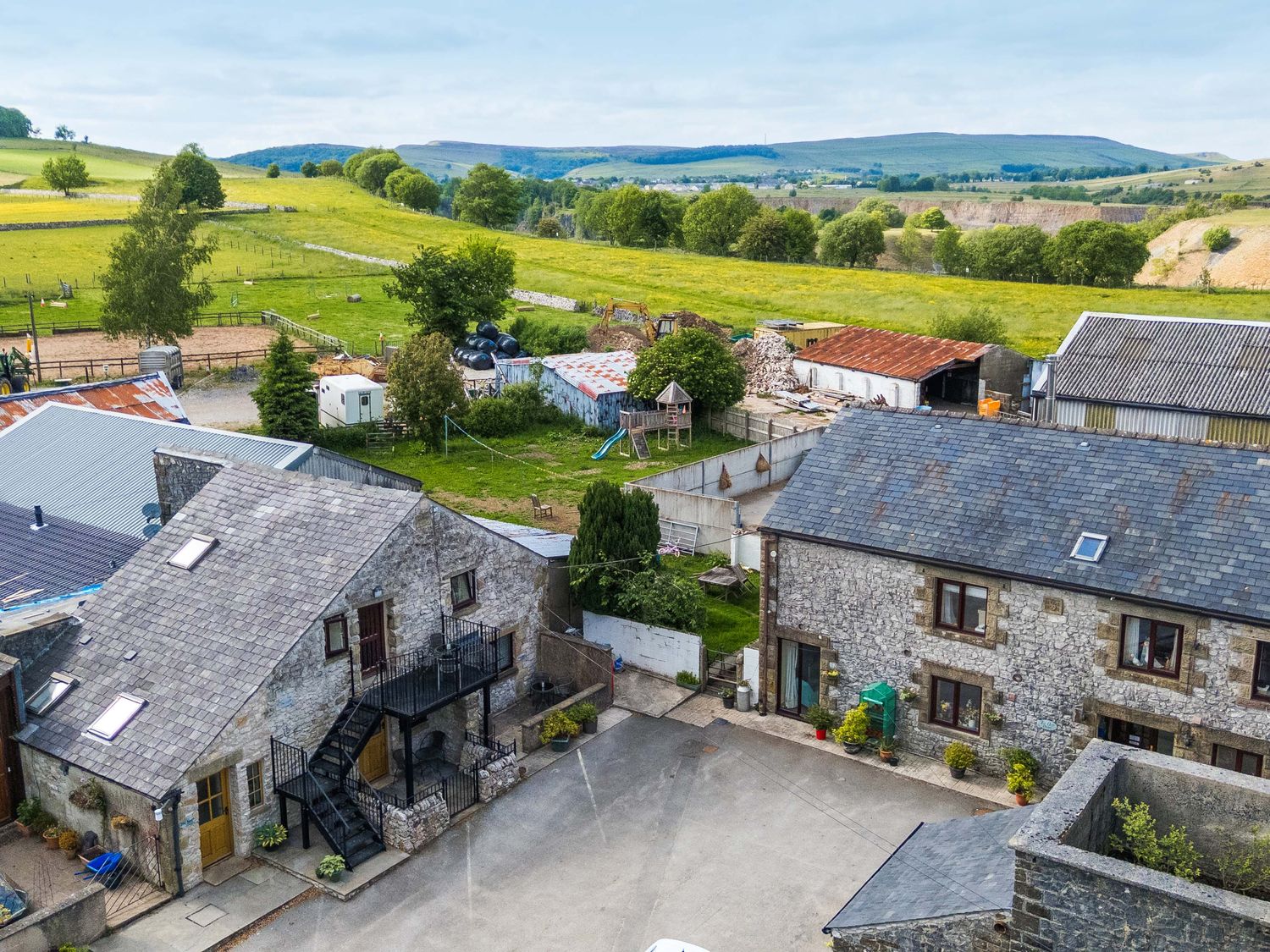 An outdoor view of buildings and fields at Woodlands in Cowdale near Buxton