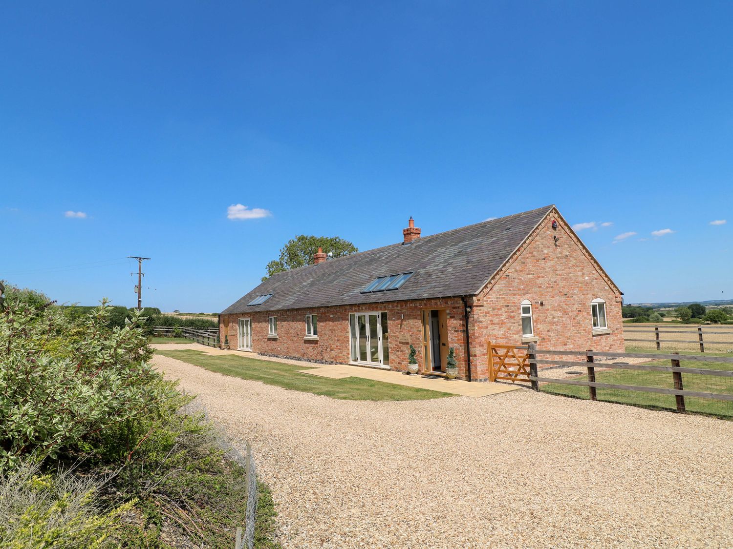 A house with a gravel driveway and garden at Teal Cottage in Melton Mowbray