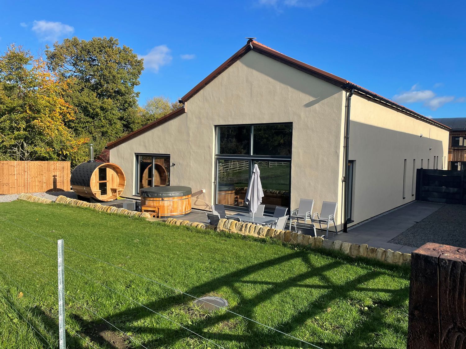 An outdoor view of a modern building with hot tub and patio at 1 New Dairy Barn in Croxdale