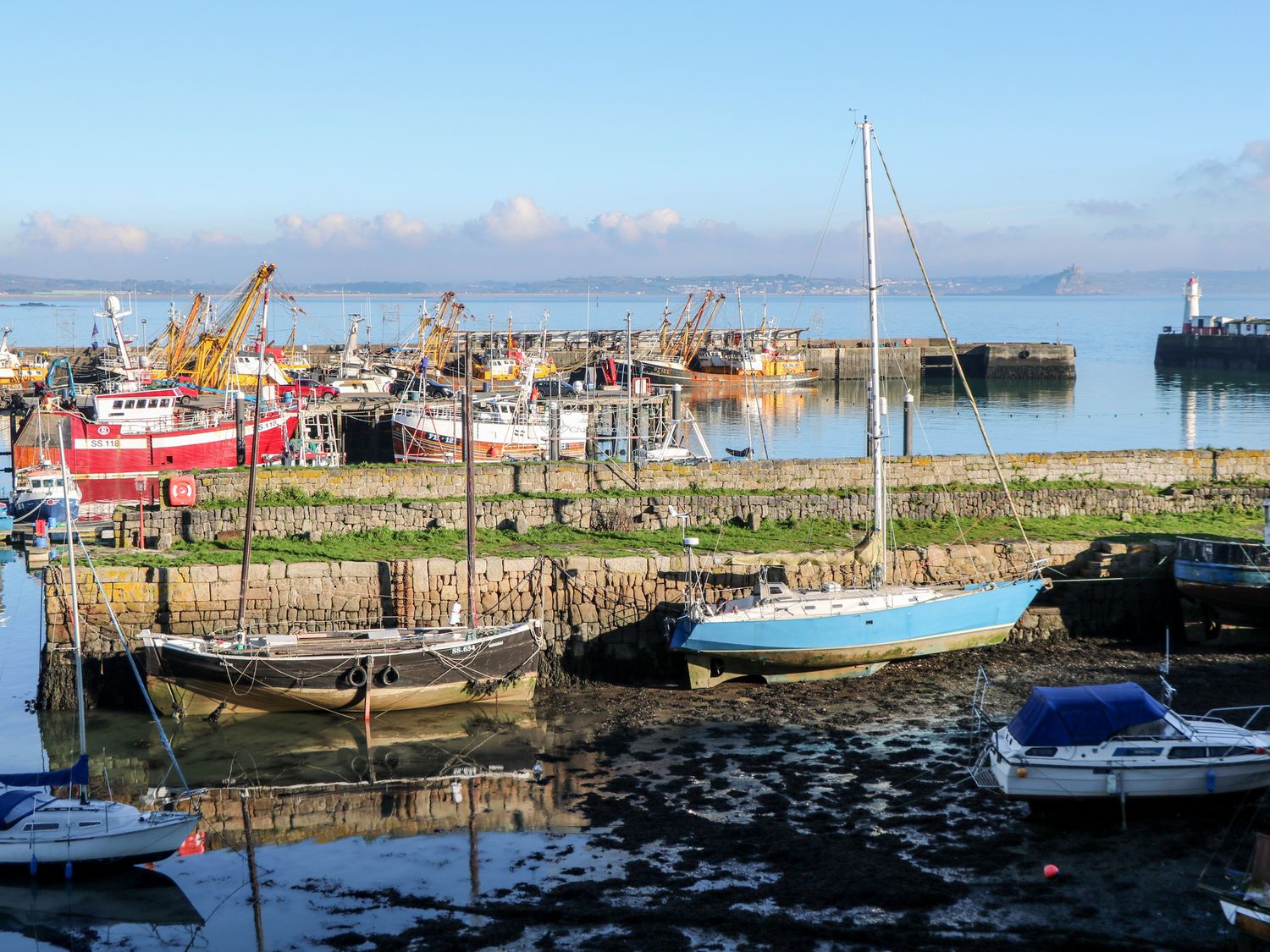 A harbor with various boats docked and dry on the shore at 21 Alverton Street in Penzance