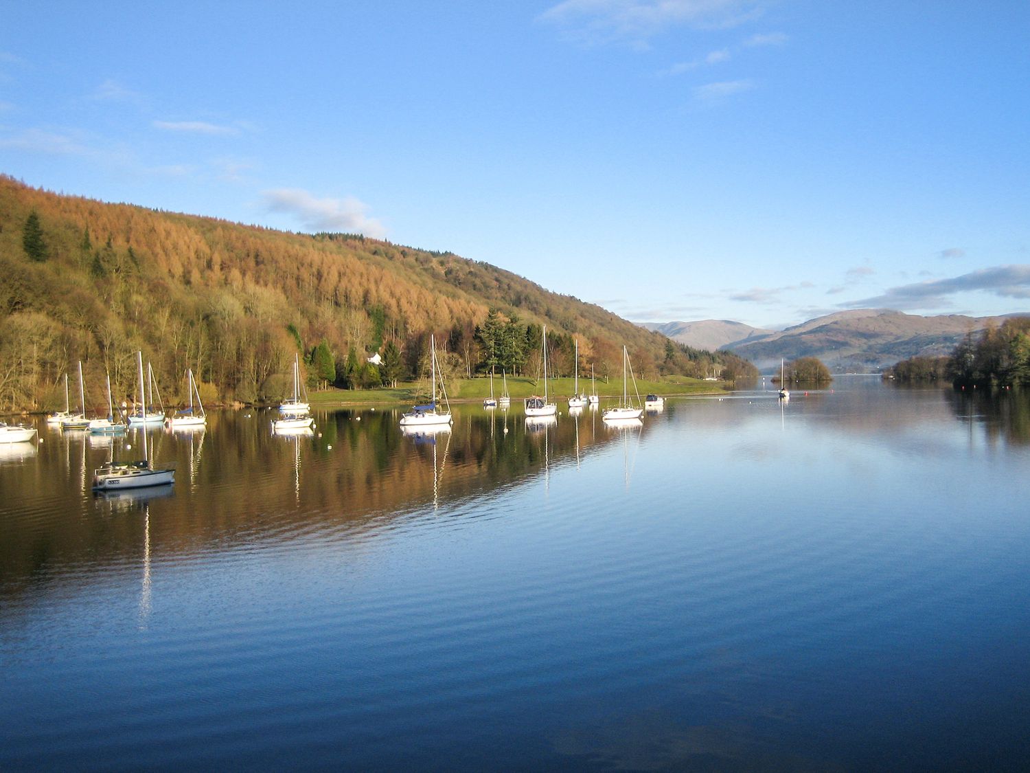 A lake with boats anchored near the shore and hills in the background at Lund in Far Sawrey