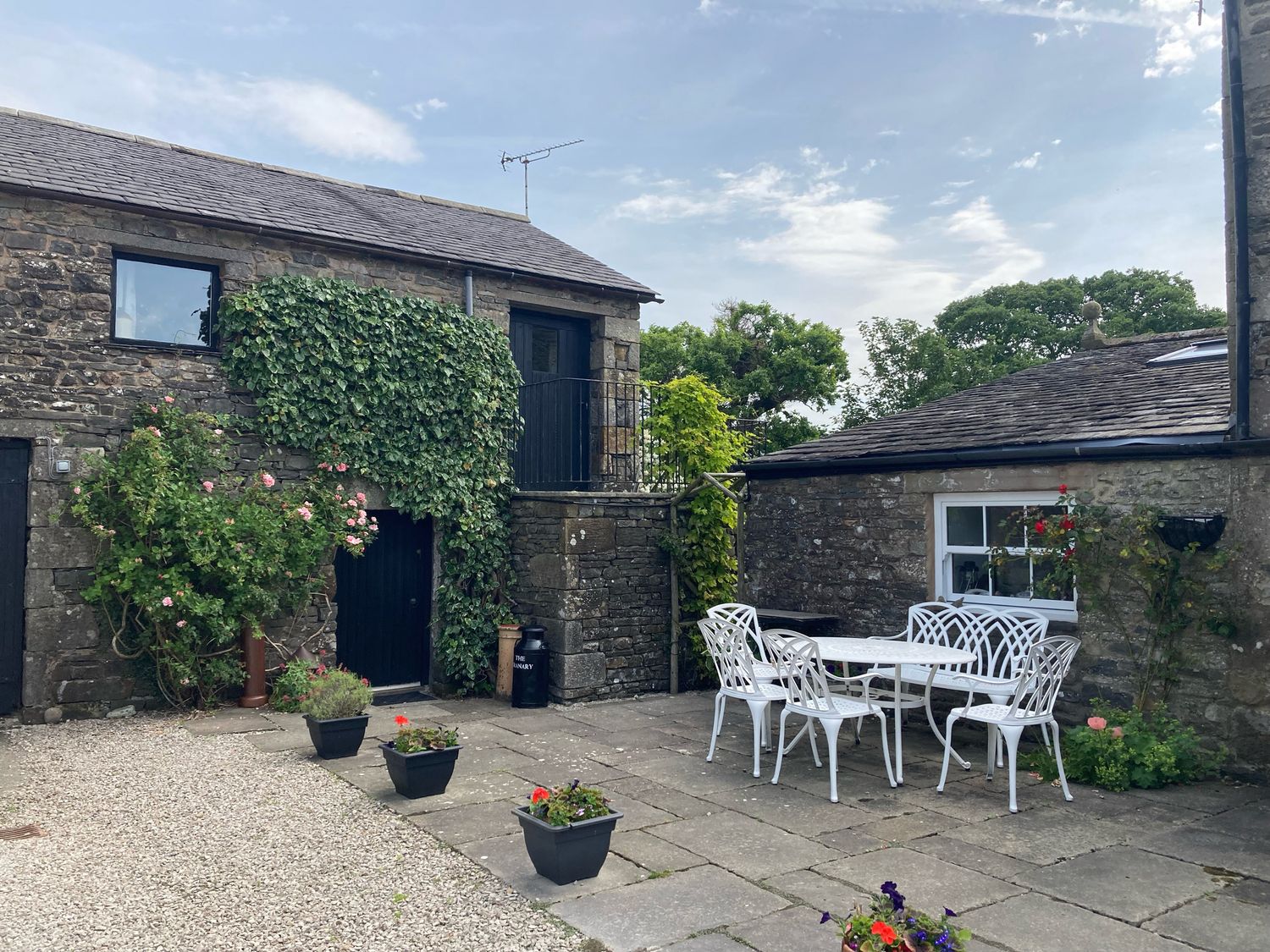 An outdoor seating area with a table and chairs at The Granary in Mansergh near Kirkby Lonsdale
