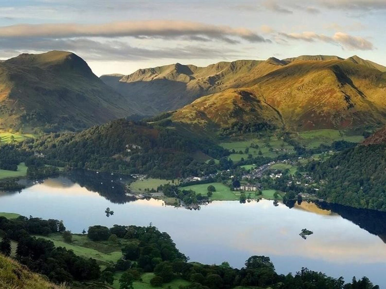 A landscape with a lake surrounded by mountains and green fields at Highgate in Hutton John near Ullswater