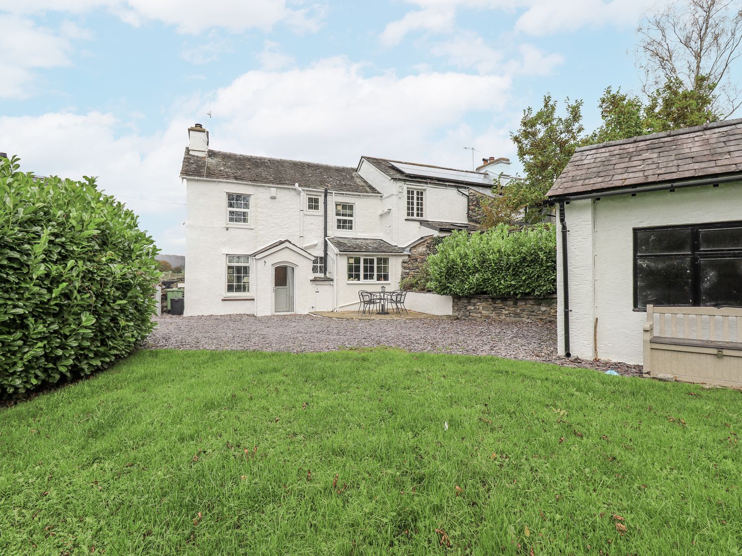 A house with a garden and patio furniture at Smithy Cottage at Bowland Bridge, Bowness