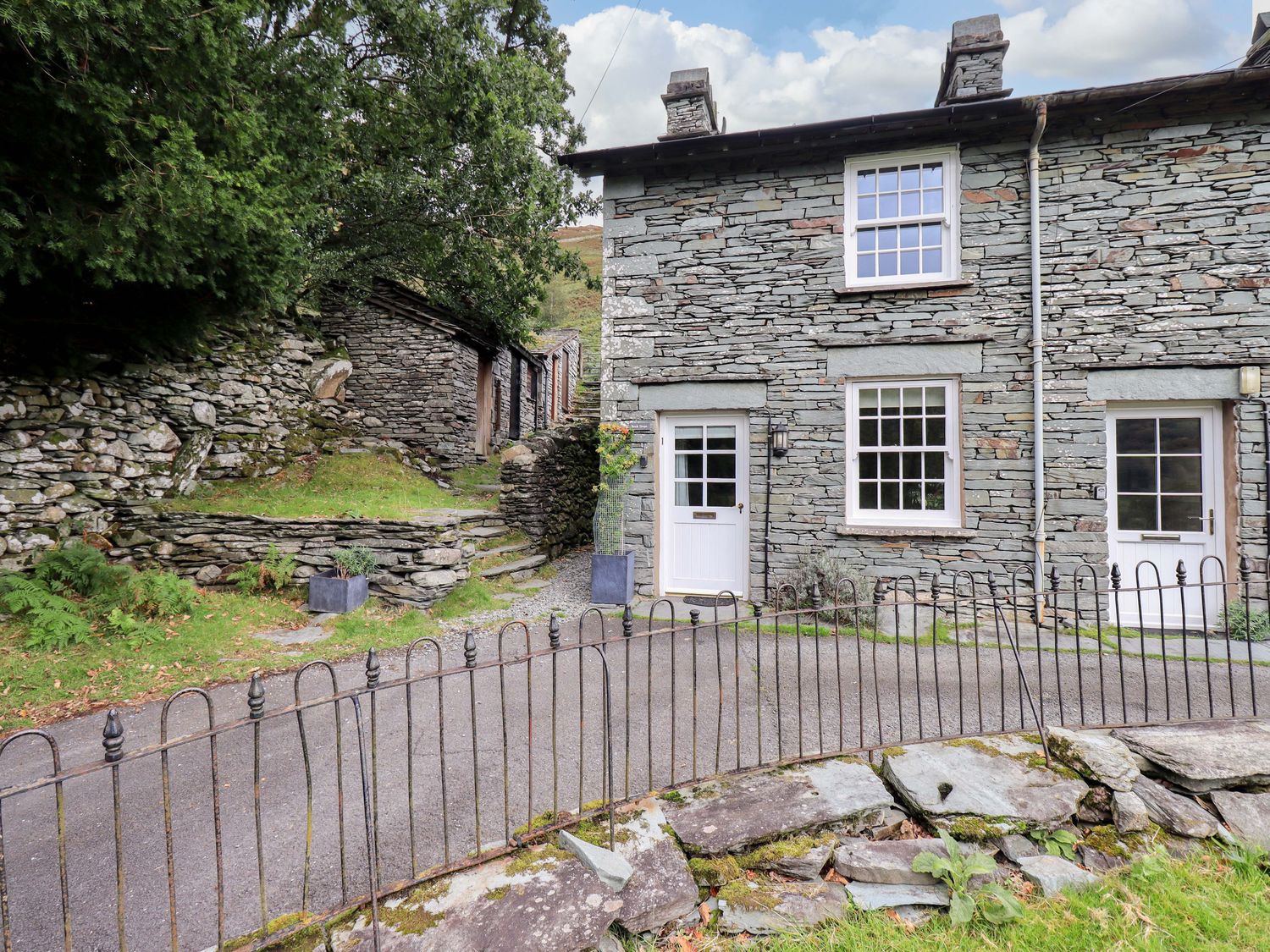 A stone house with windows and doors in an outdoor area at Beck Steps in Chapel Stile