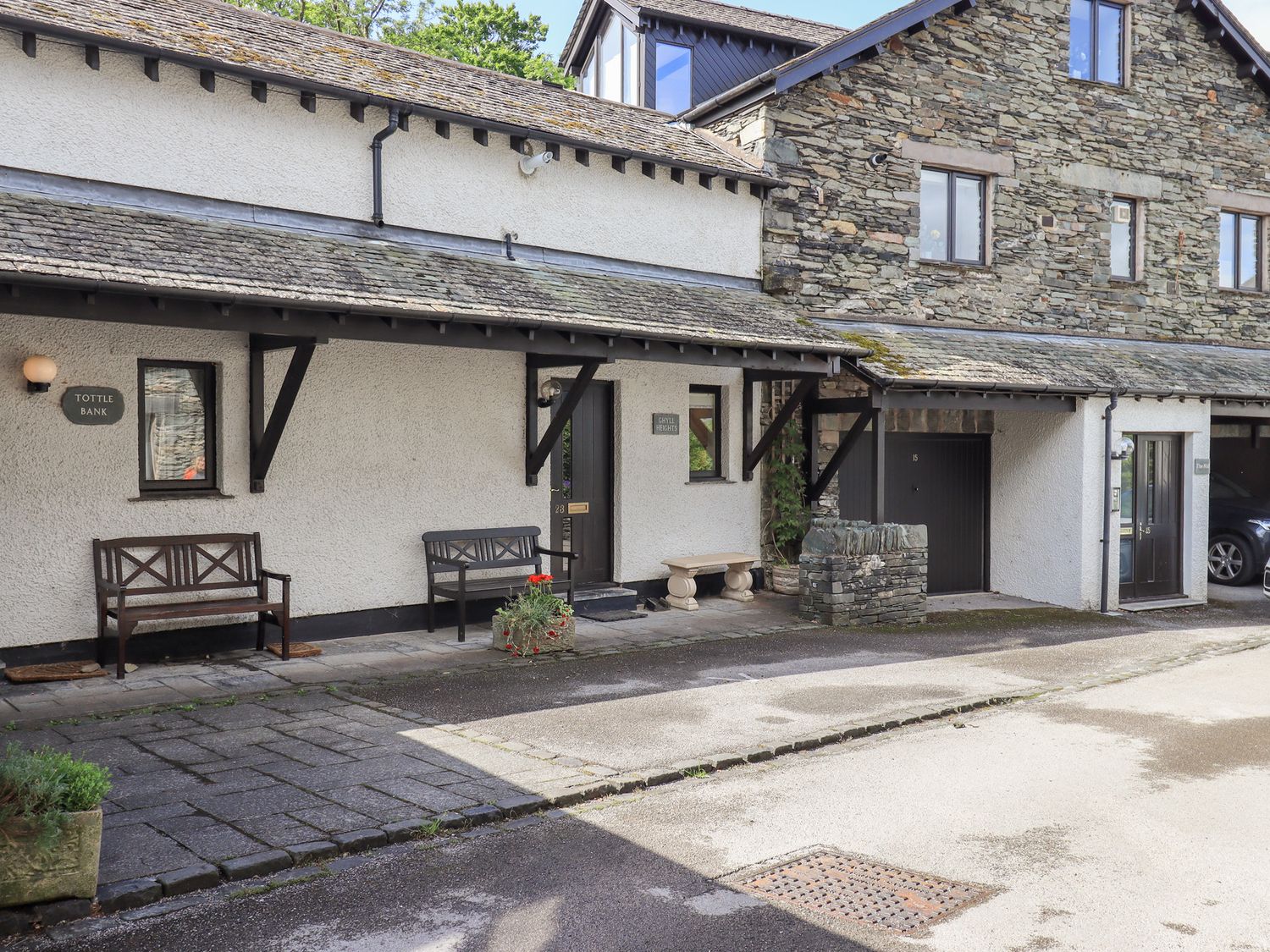An outdoor area with benches and a stone wall at Ghyll Heights in Ambleside