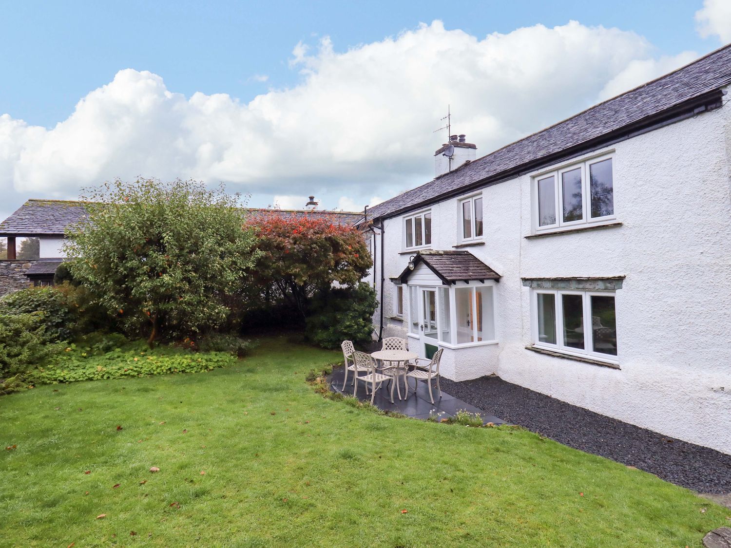 A house with a garden and seating area at Ecclerigg Old Farm near Ambleside