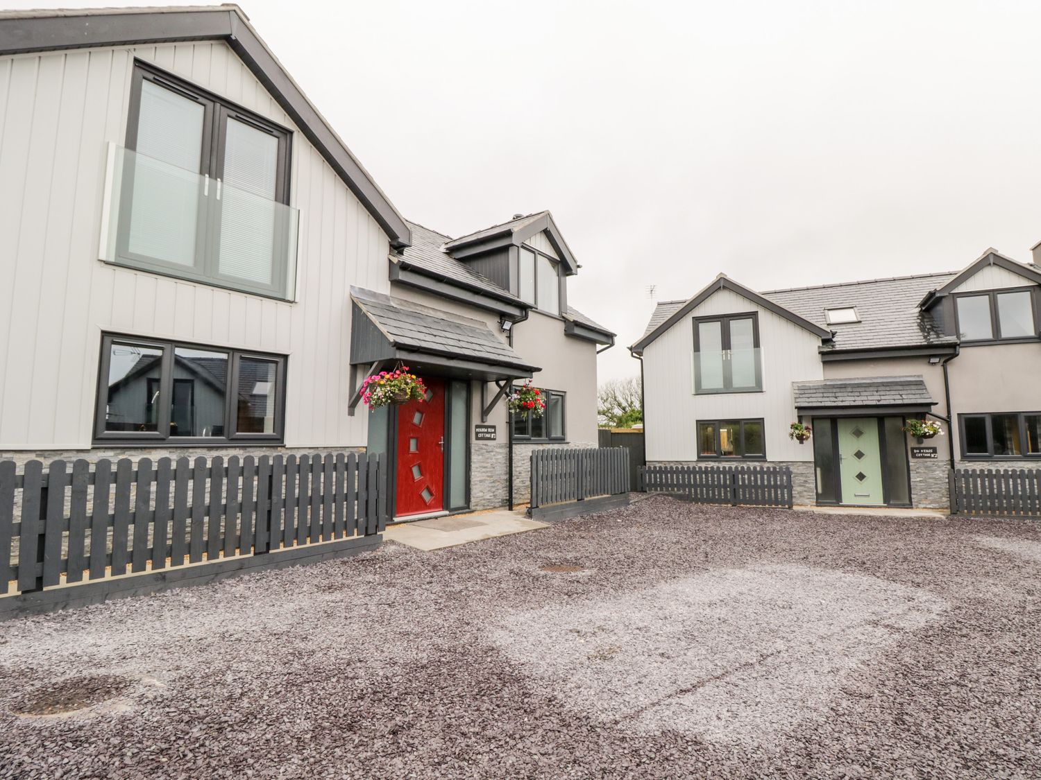 Two modern houses with slate roofs and fenced front yards at Meadow View in Tyn-y-Gongl near Benllech