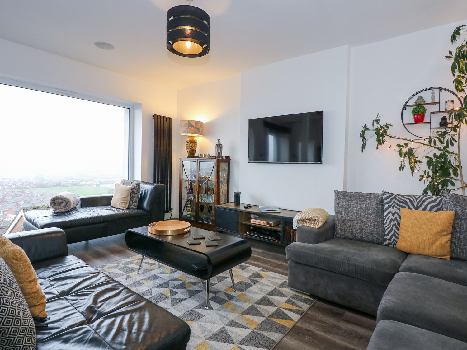 A living room with sofas a coffee table and a wall-mounted television at Sea View in Penrhyn Bay