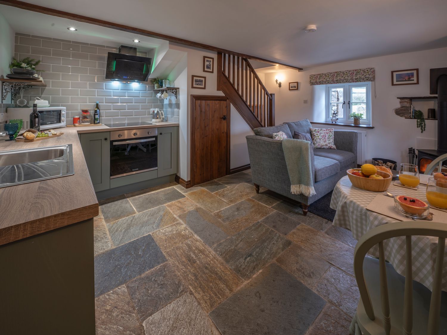A kitchen and living area with a stove sofa and dining table at Crooks in Axbridge
