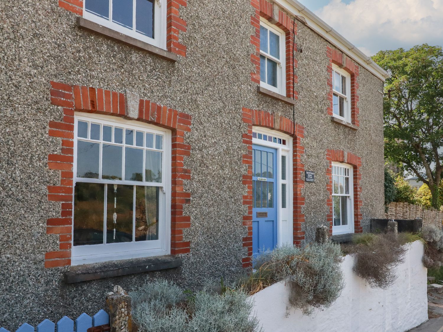A house exterior with windows and a front door at Trevethen Cottage in Crantock