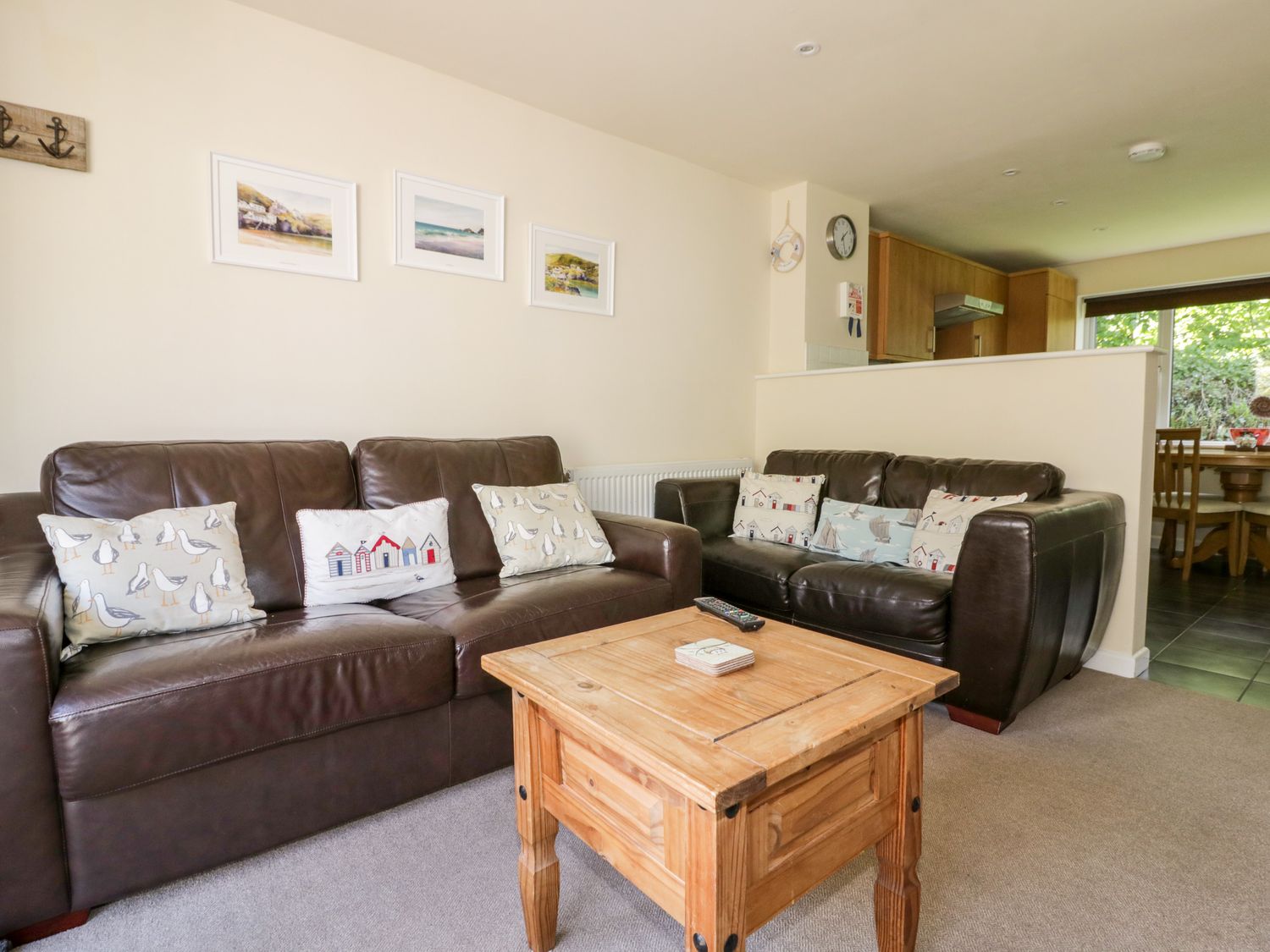 A living room with two brown leather sofas and a wooden coffee table at 49 Atlantic Reach in Newquay