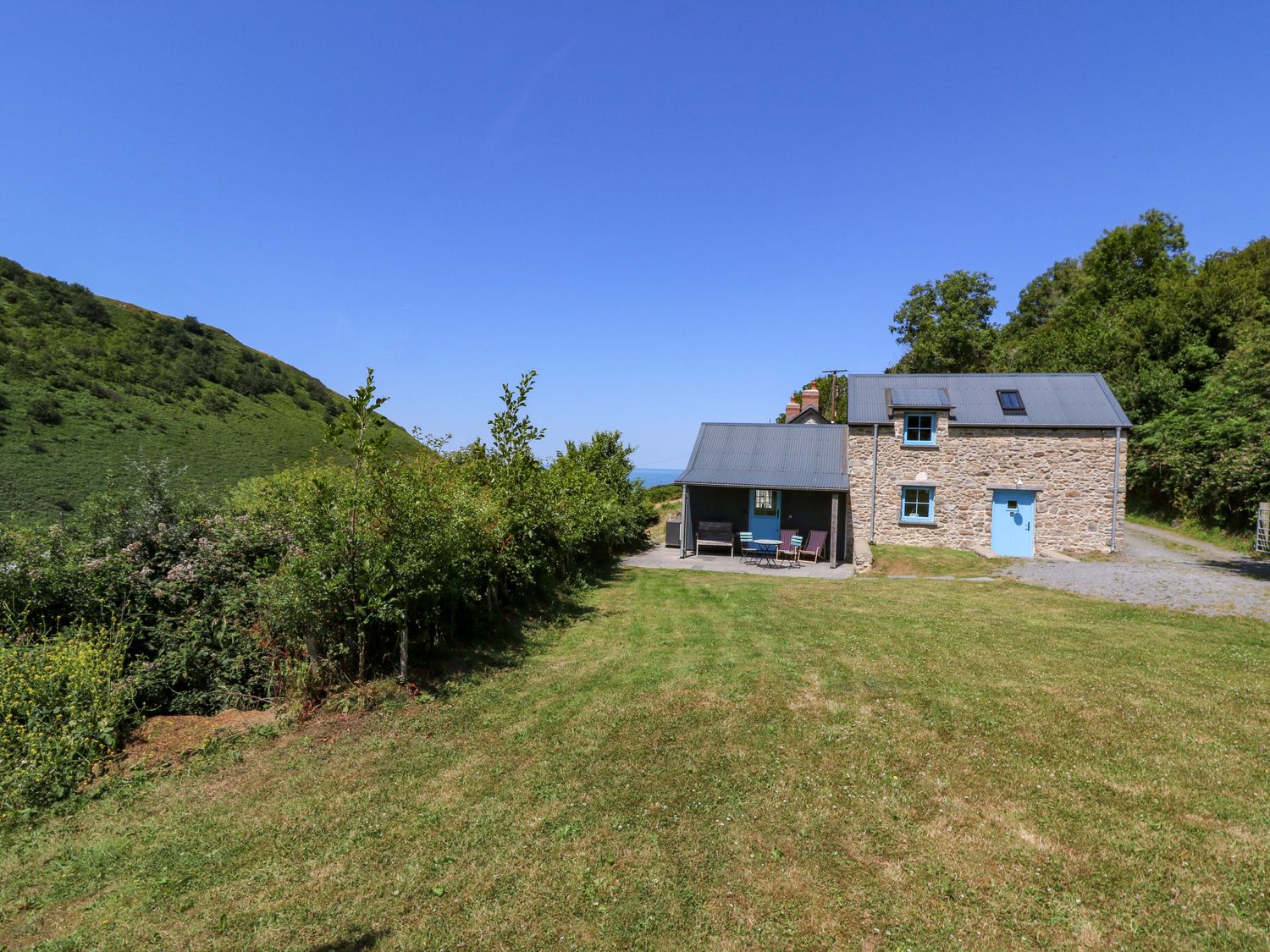 A house with a hill and sky at Dolwylan Barn Cwmtydu near New Quay