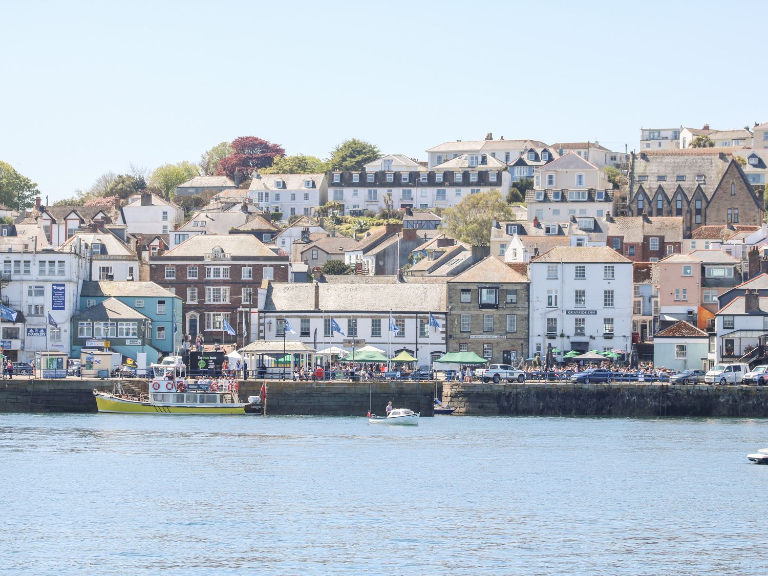 A harbor with boats in front of buildings and houses on a hill at Owls Roost in Pendra Loweth near Falmouth