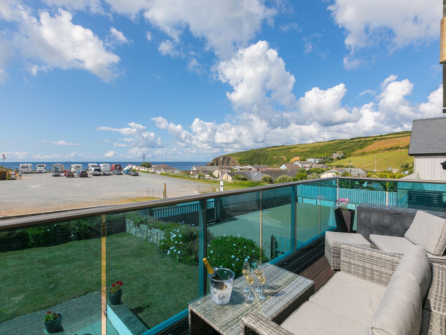 A balcony with seating and sea view at Sandbanks in Praa Sands