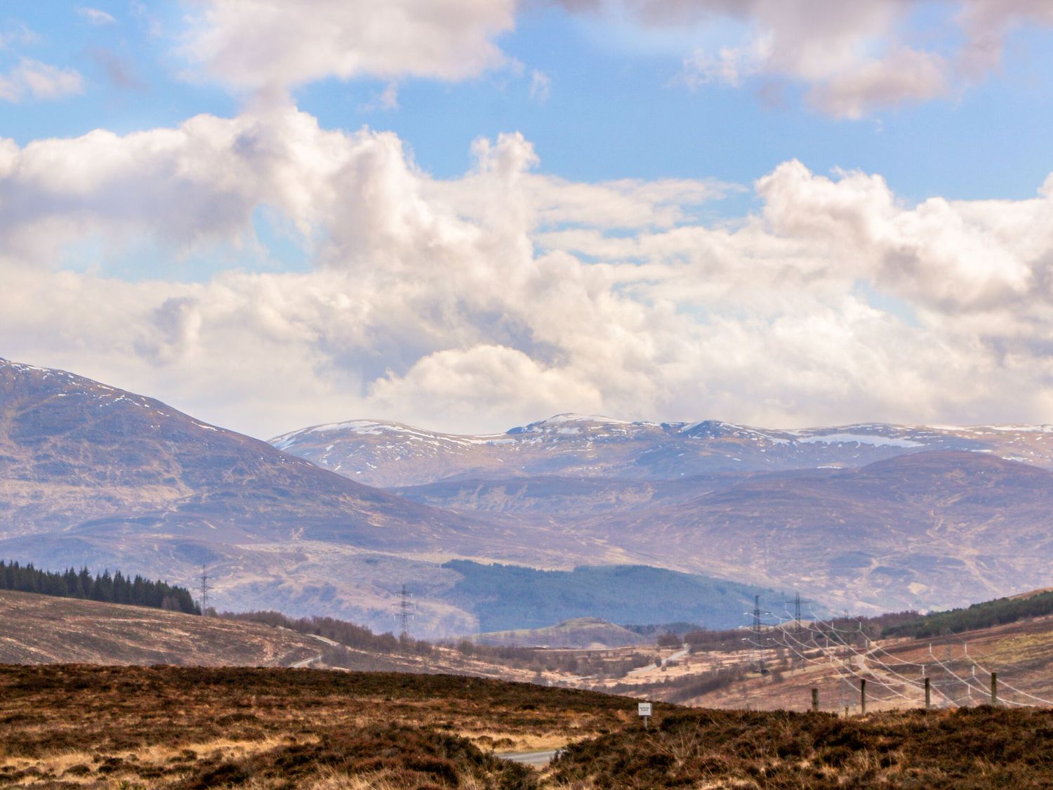 A rural landscape with hills mountains and power lines under a cloudy sky at Mary Ann Villa Inverness