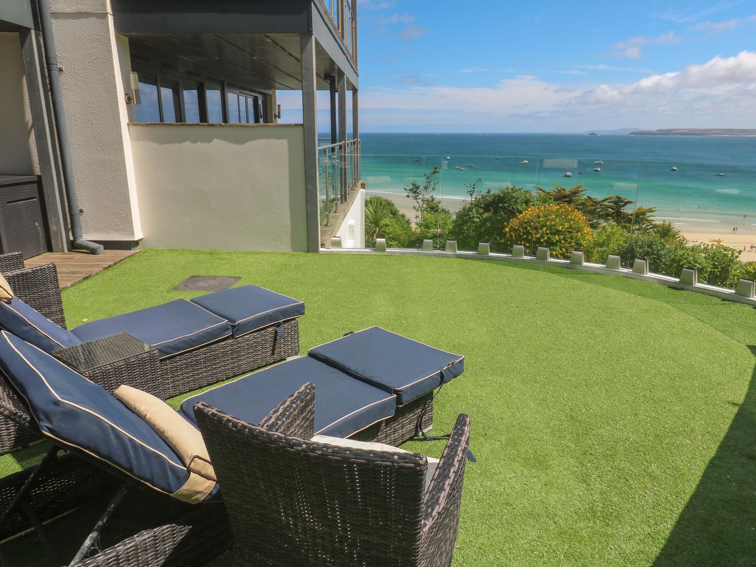 An outdoor area with chairs and an ocean view at Peninsula Apartment 2 St Ives