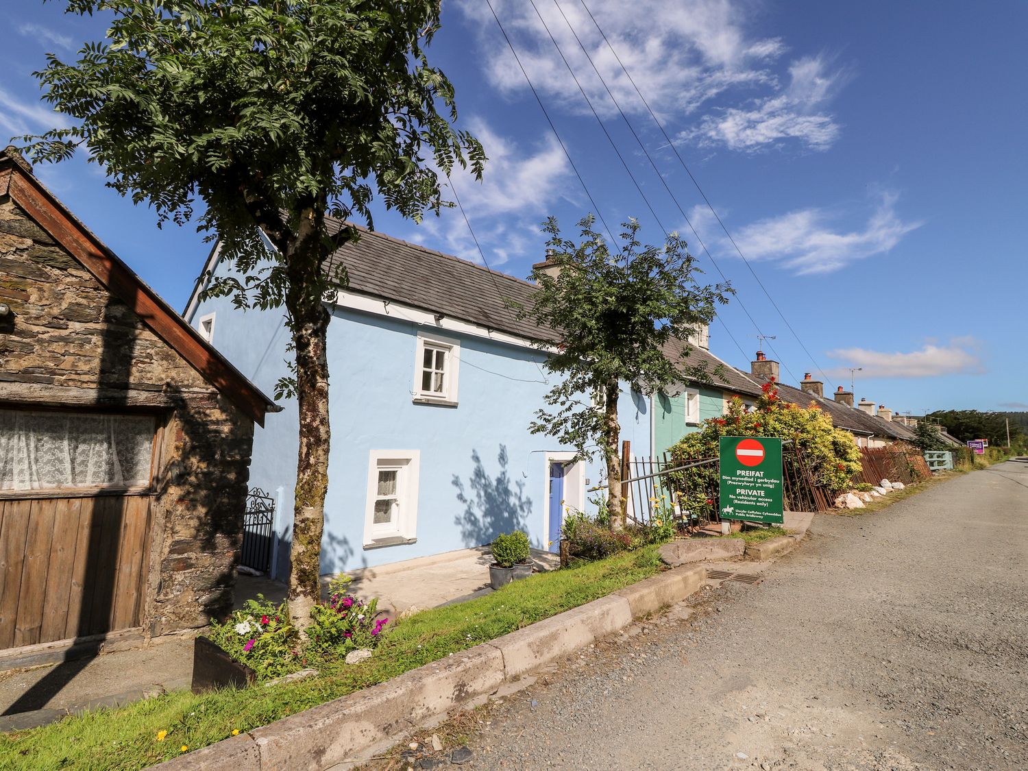 A row of cottages along a roadside with trees and a private access sign at 1 The Terrace Rosebush near Newport Pembrokeshire