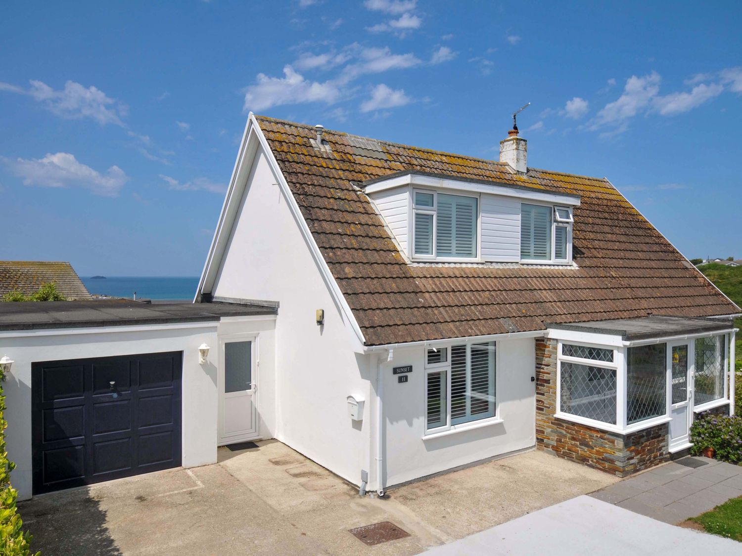 A house with a garage and windows at Sunset in Polzeath