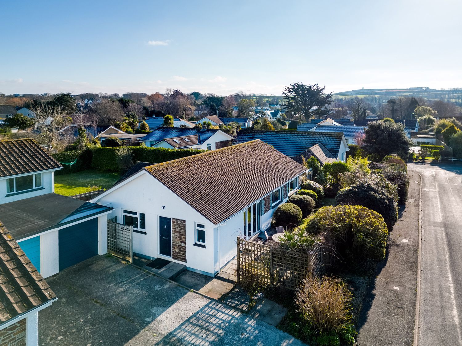 A white bungalow with a tiled roof and garage on a residential street at Little Sailing in Rock