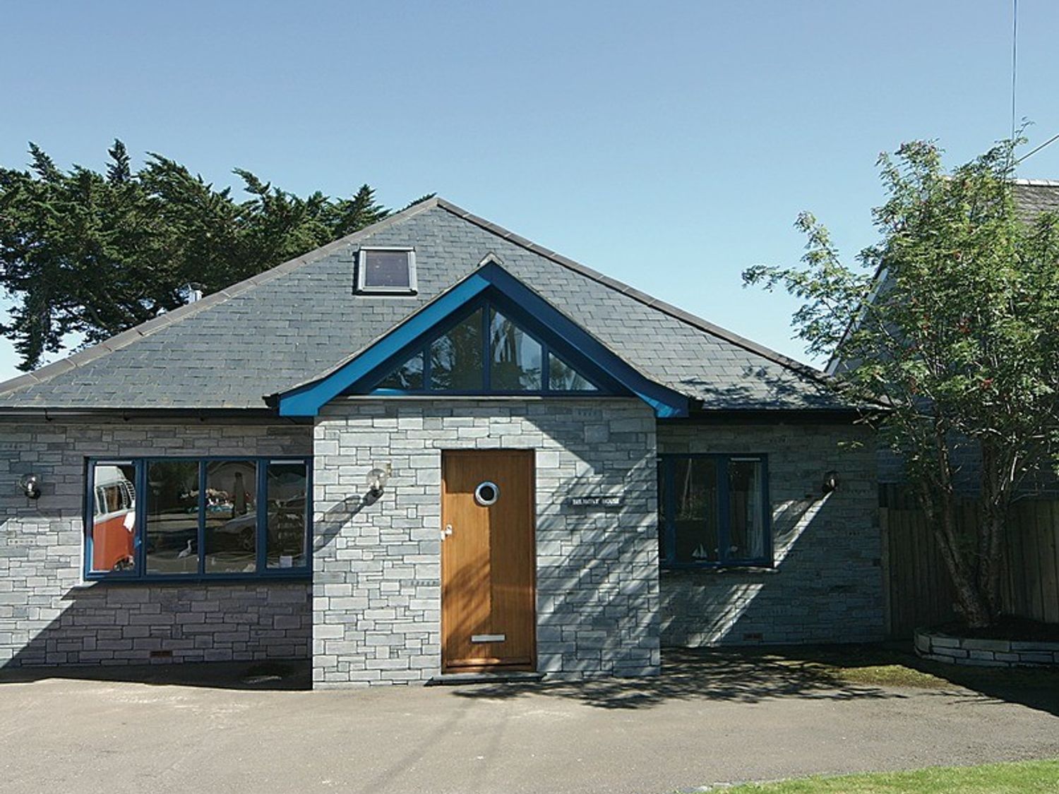A stone house with a wooden door and triangular window above at Belmont in Rock