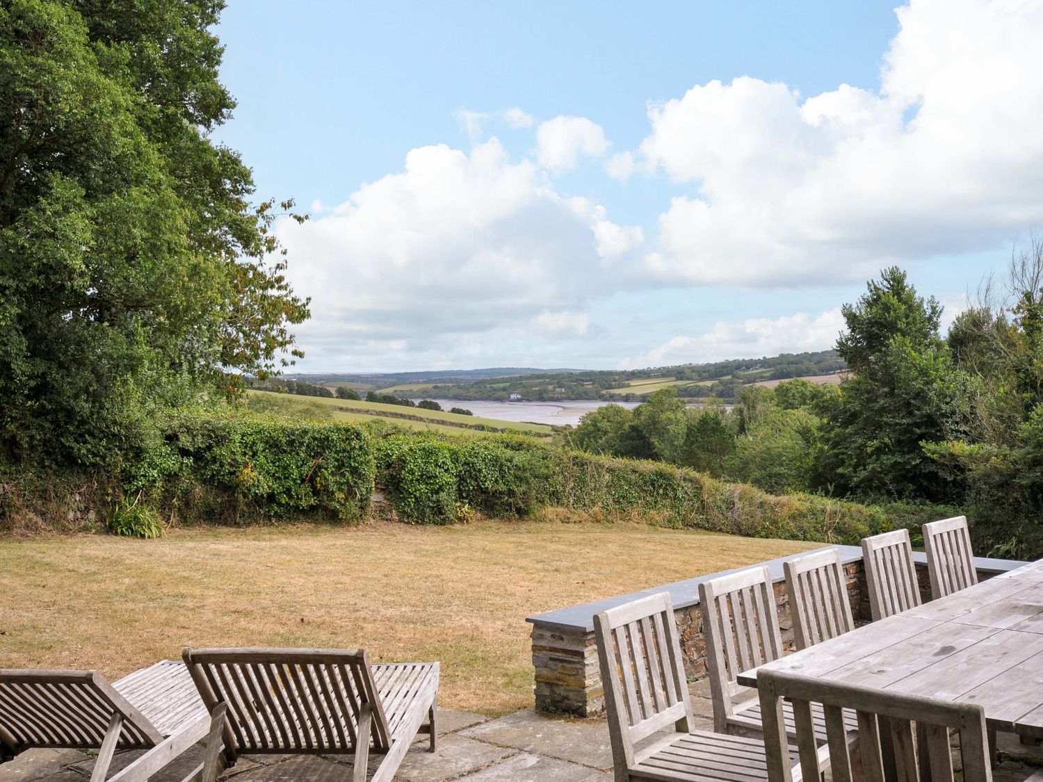 A garden with deck chairs and a dining table at The Old Granary in Rock