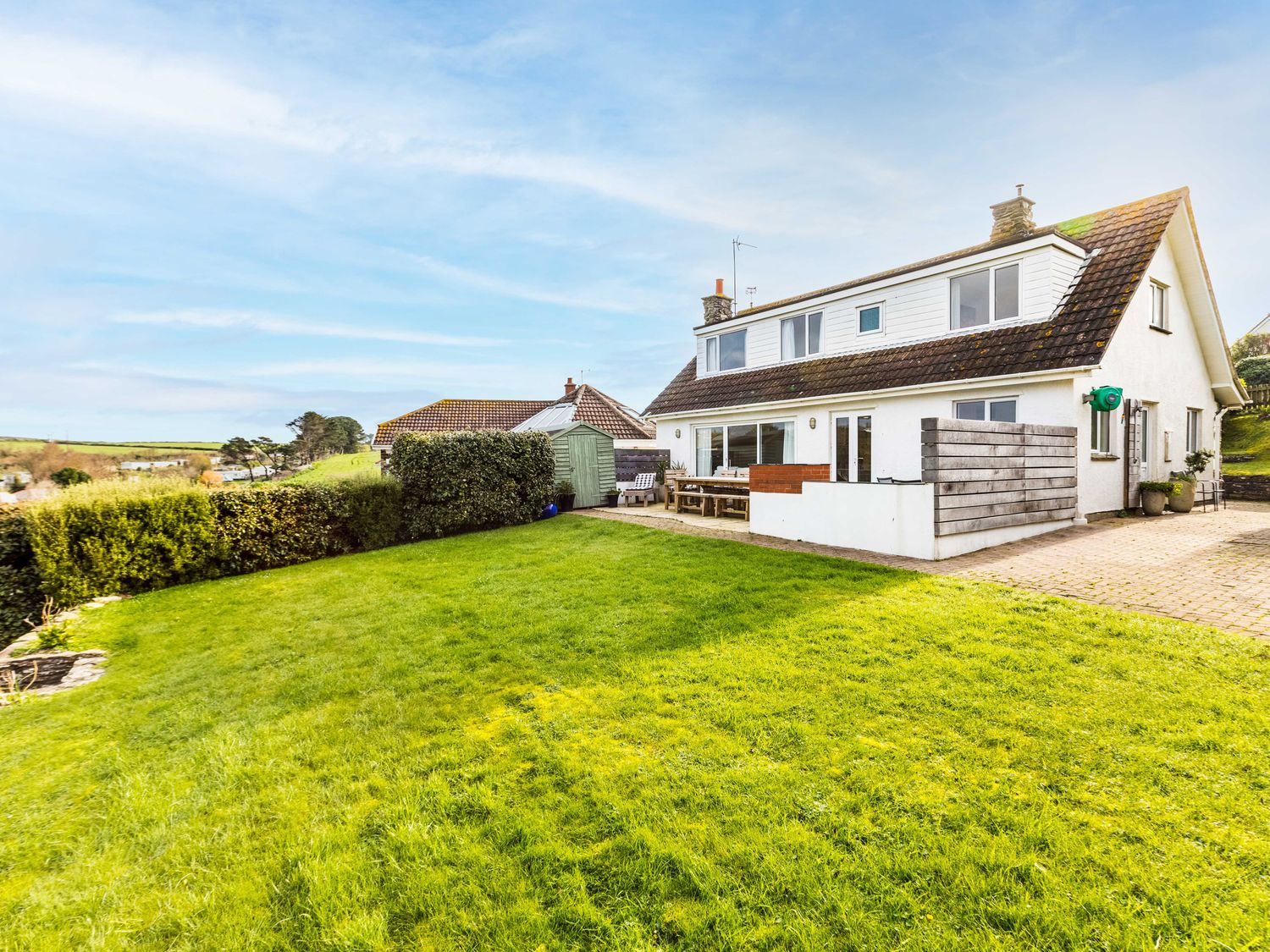 A house with a lawn a garden shed and outdoor seating at Westpoint in Polzeath