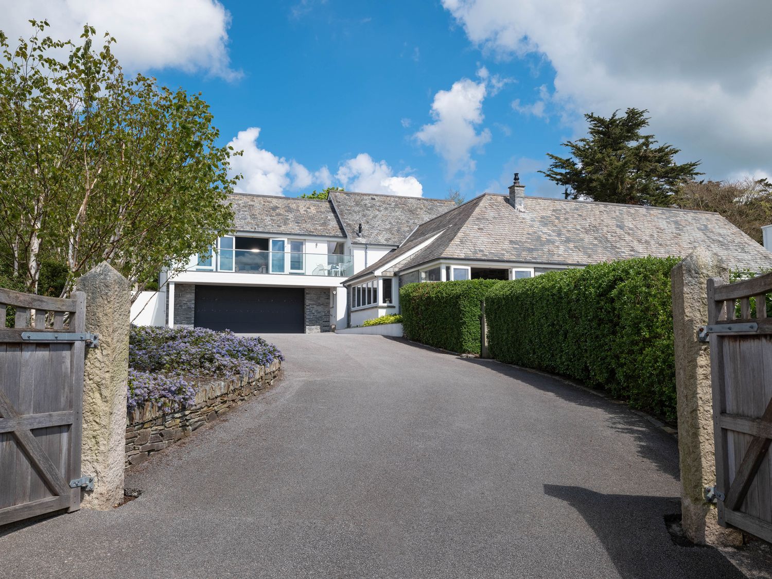 A driveway leading to a house with a garage gate and bushes at Landers Field in Rock