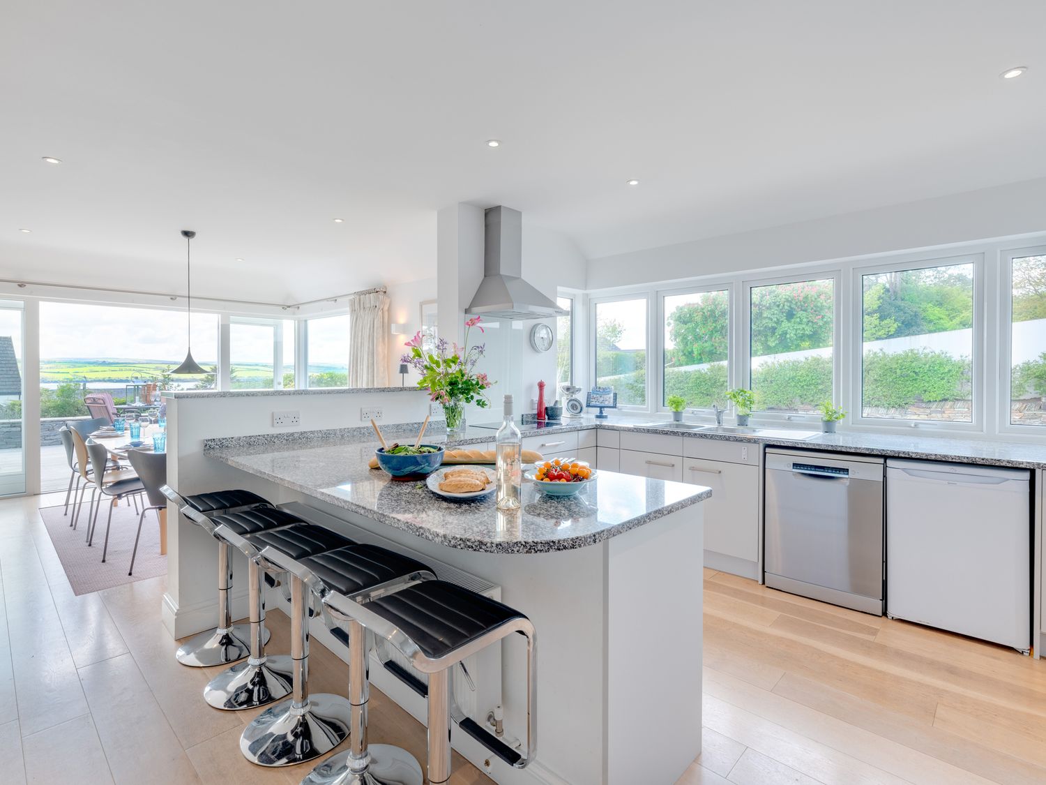 A kitchen with a granite countertop island and bar stools next to a dining table at Landers Field in Rock