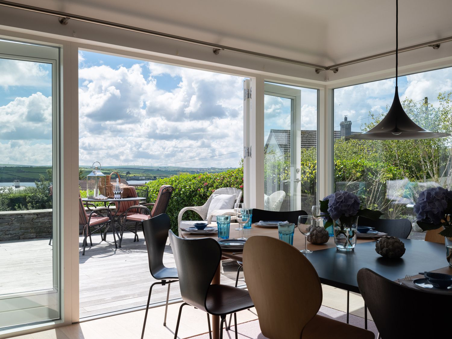 A dining area with a set table and glass doors opening to an outdoor patio with chairs and a table at Landers Field in Rock
