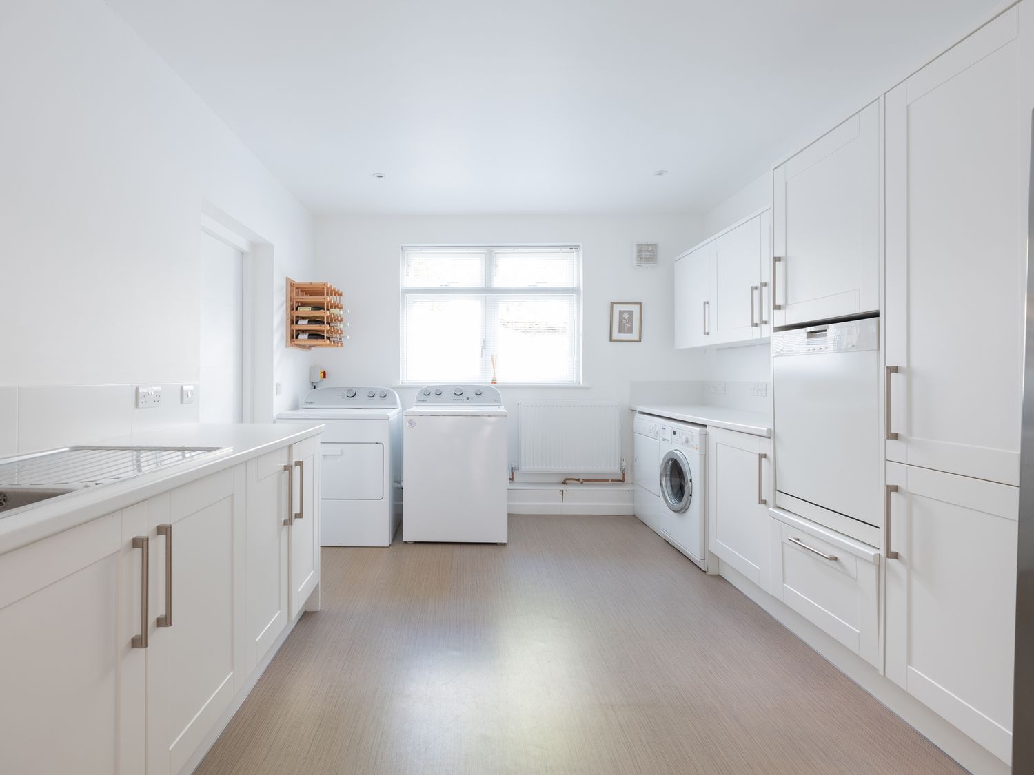 A utility room with washer and dryer under a window and white cabinets at Landers Field in Rock