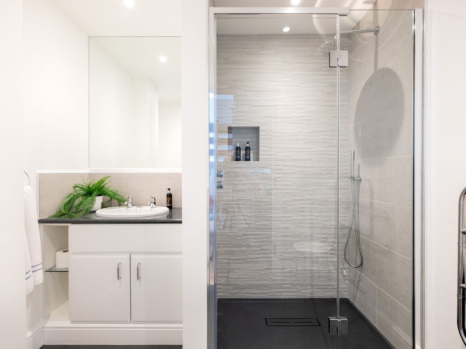 A bathroom with a sink and countertop next to a glass-enclosed shower at Landers Field in Rock