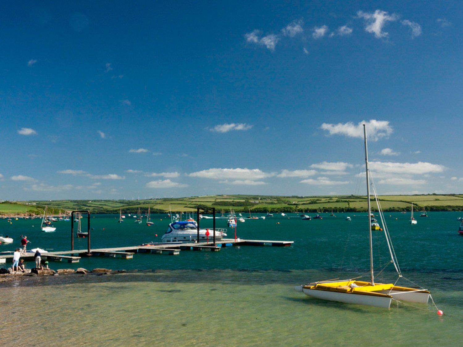 A marina with boats on water and people near a dock at Upper Deck in Rock
