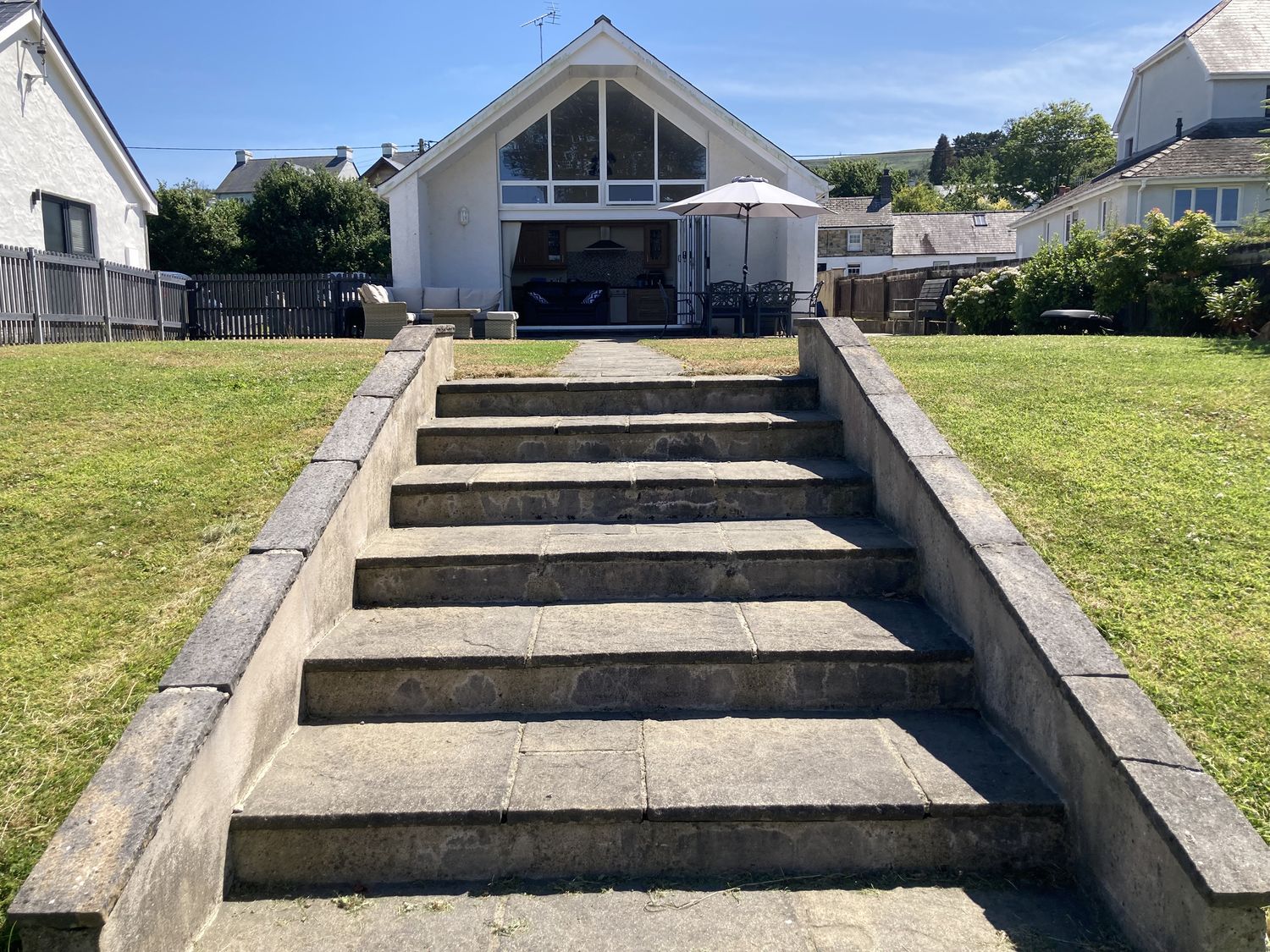 A garden with steps leading to a patio at Awel Deg, Newport