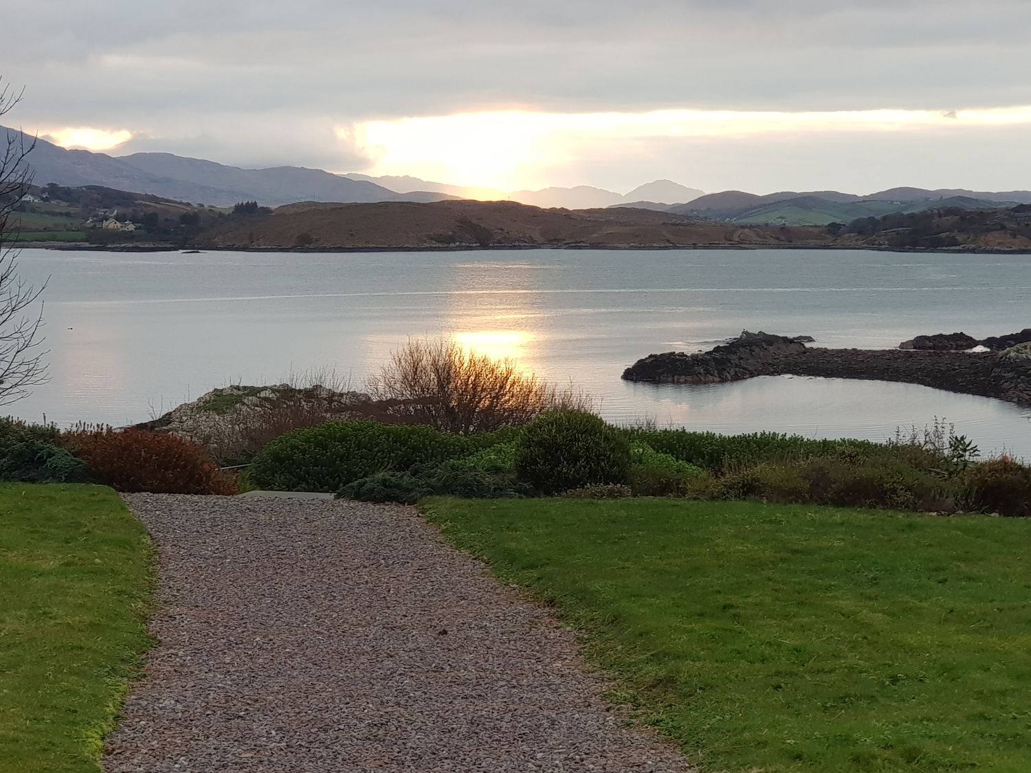 A gravel path leading to a body of water with hills and rocky shorelines in the background at Inbear Sceine Laughaunacreen near Tuosist County Kerry