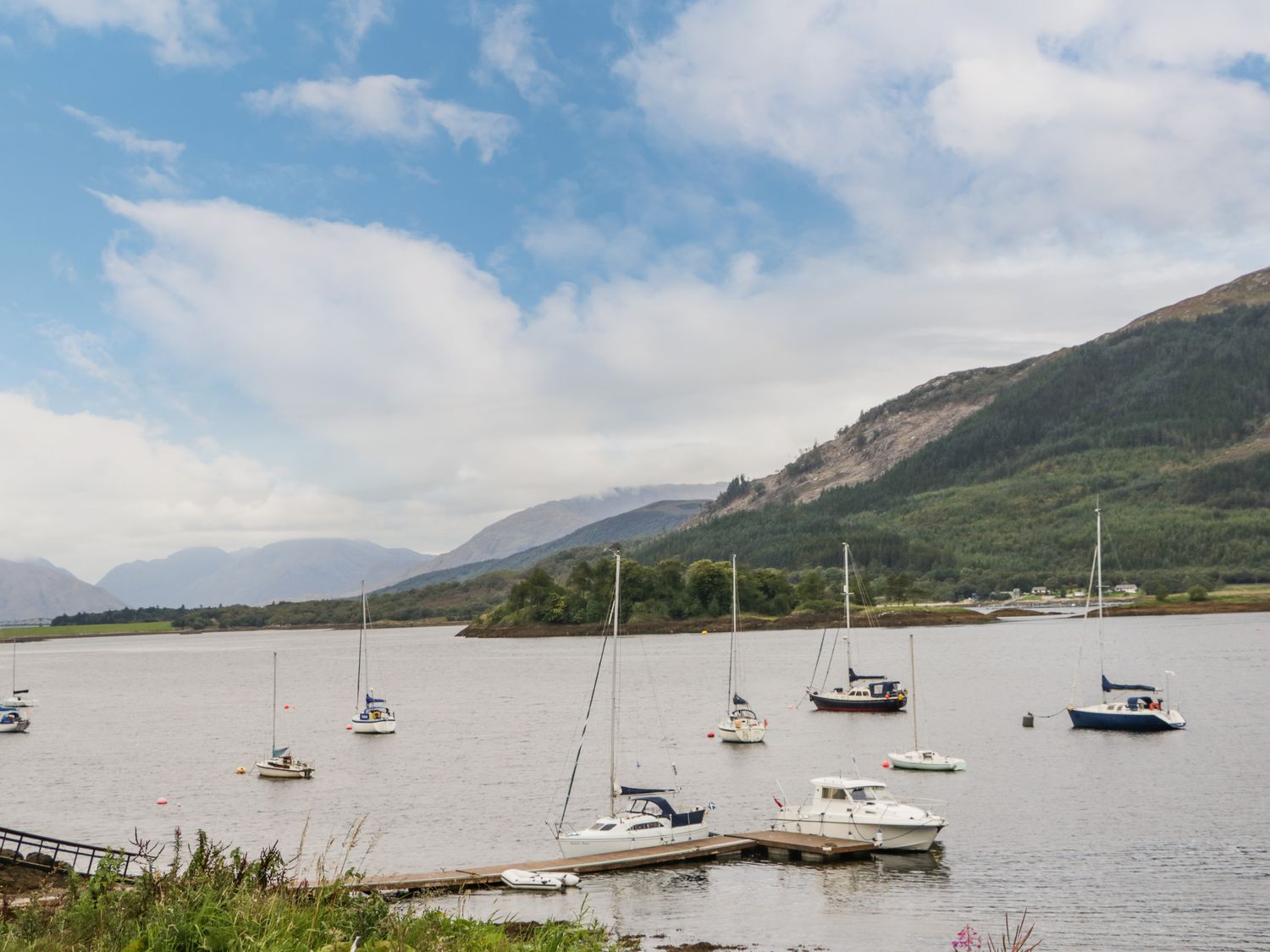 A body of water with boats docked and floating near an island and mountains in the background at Island View House in Glencoe