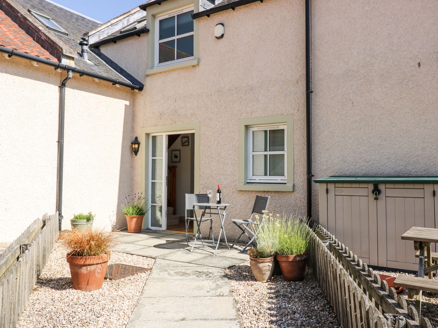 An outdoor patio with a table and chairs at 6A Pitlethie Steading Leuchars