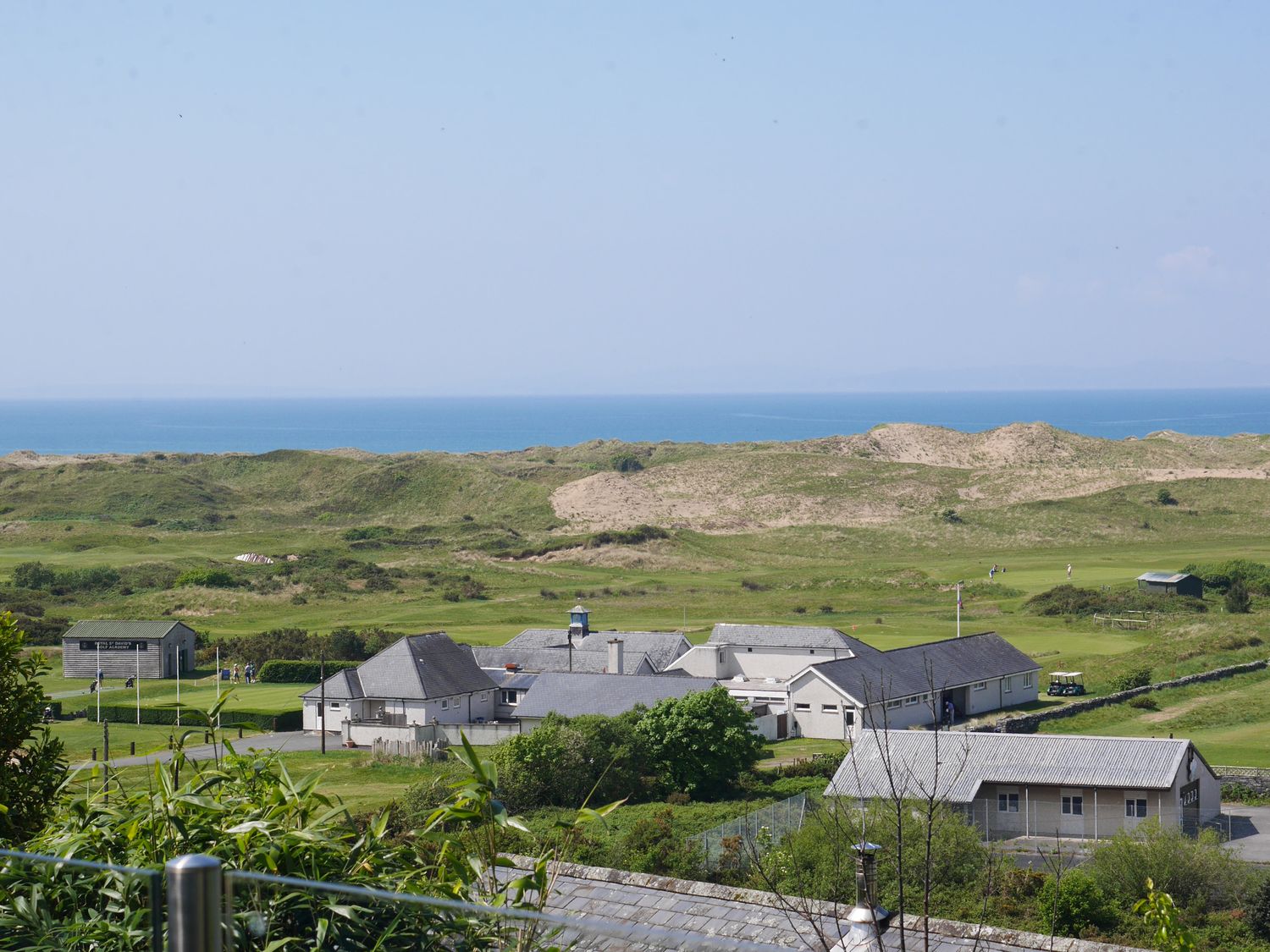 A coastal landscape with buildings golf course and sand dunes at Stoneycroft in Harlech