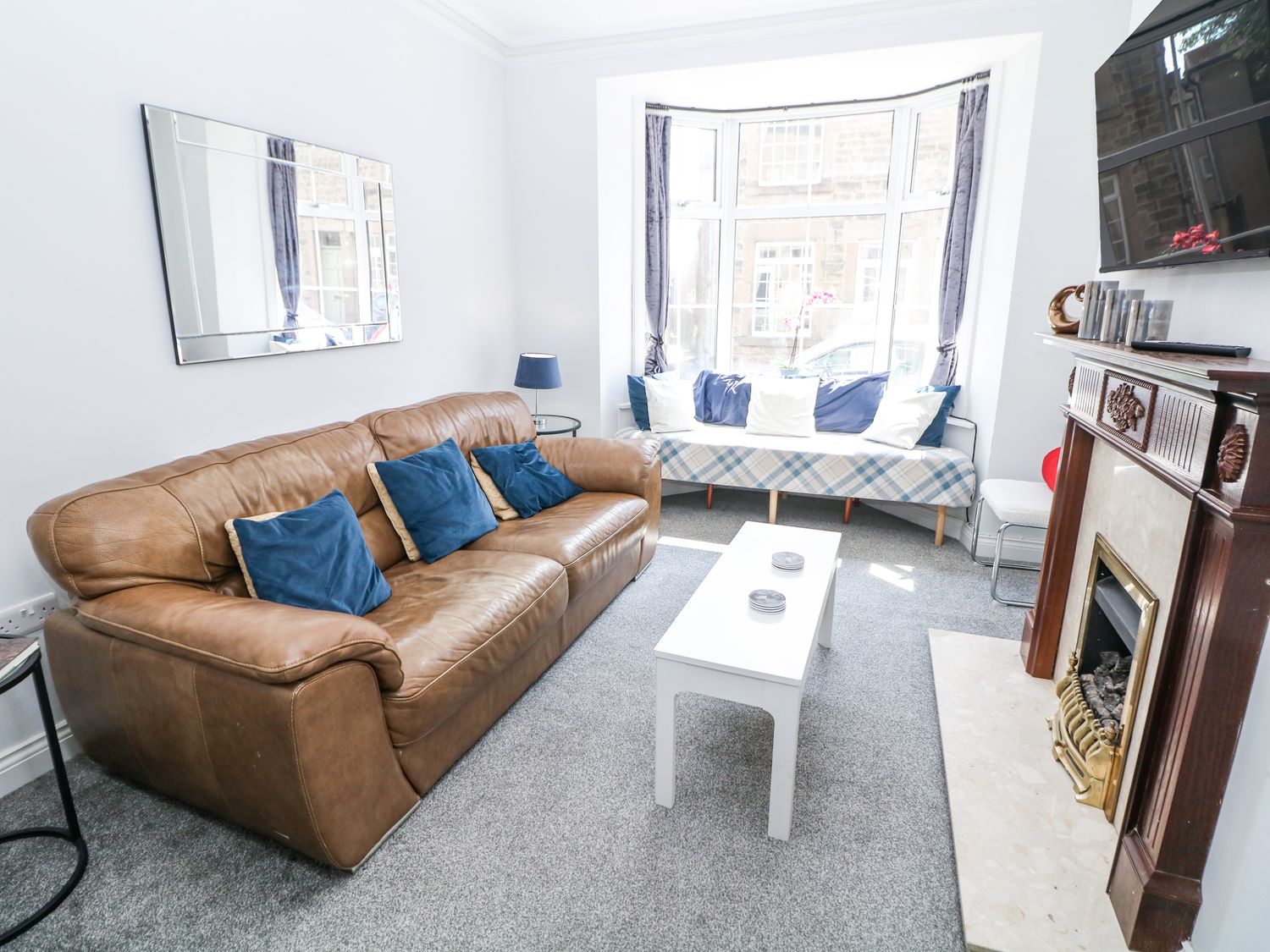 A living room with a sofa and coffee table at 15 South Avenue Mews in Buxton