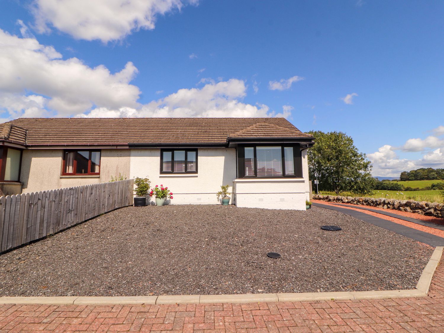 A house with gravel area and planters at The Paddock in Kirkcowan